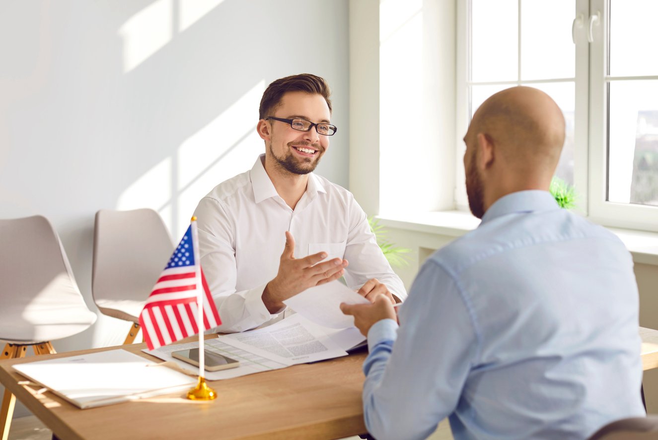 Man Sitting in the Office of the US Embassy with Immigration Application and Having Visa Interview.